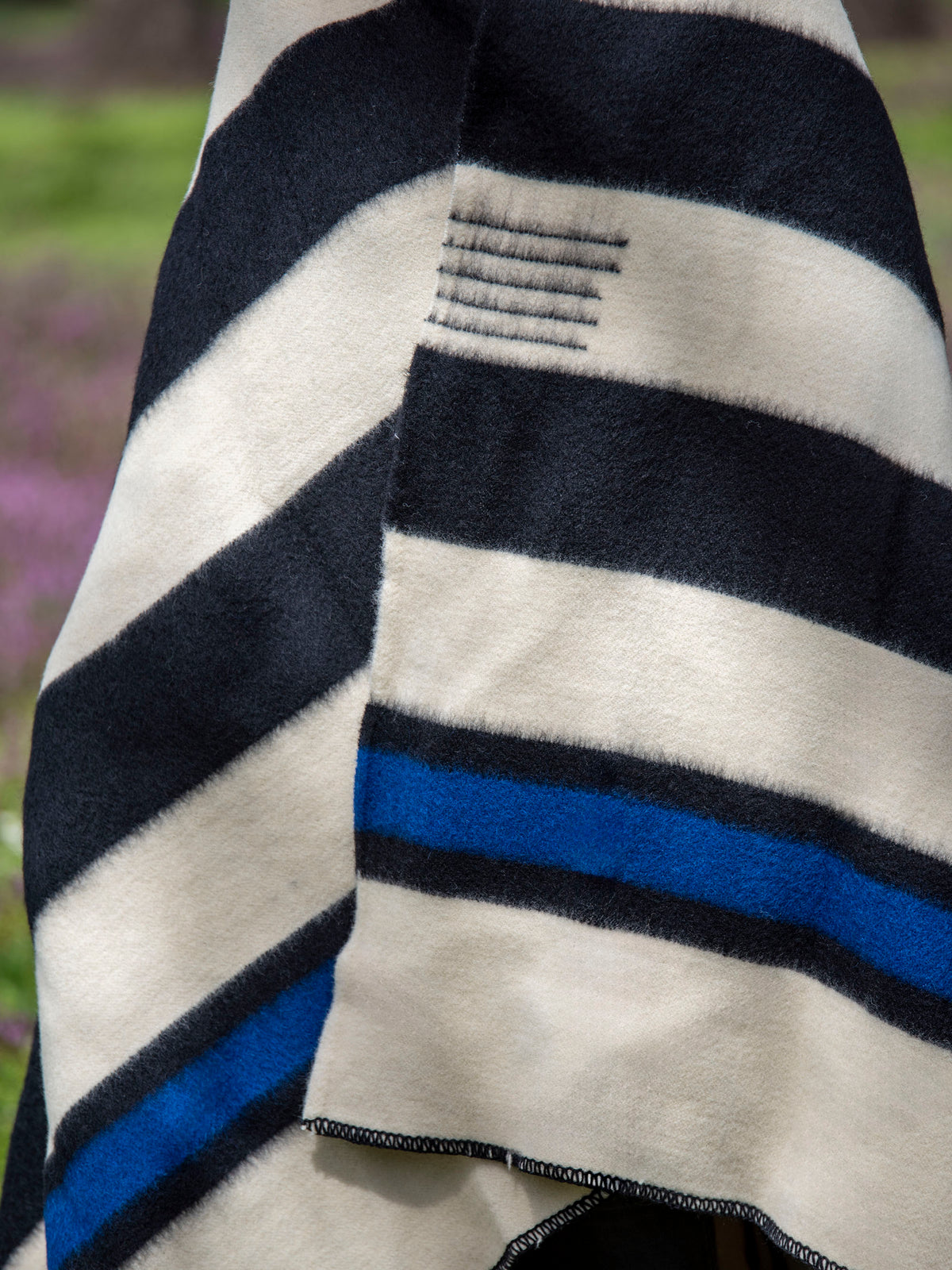 Close-up of a cozy thick striped organic wool blanket with black, blue, and white colors.