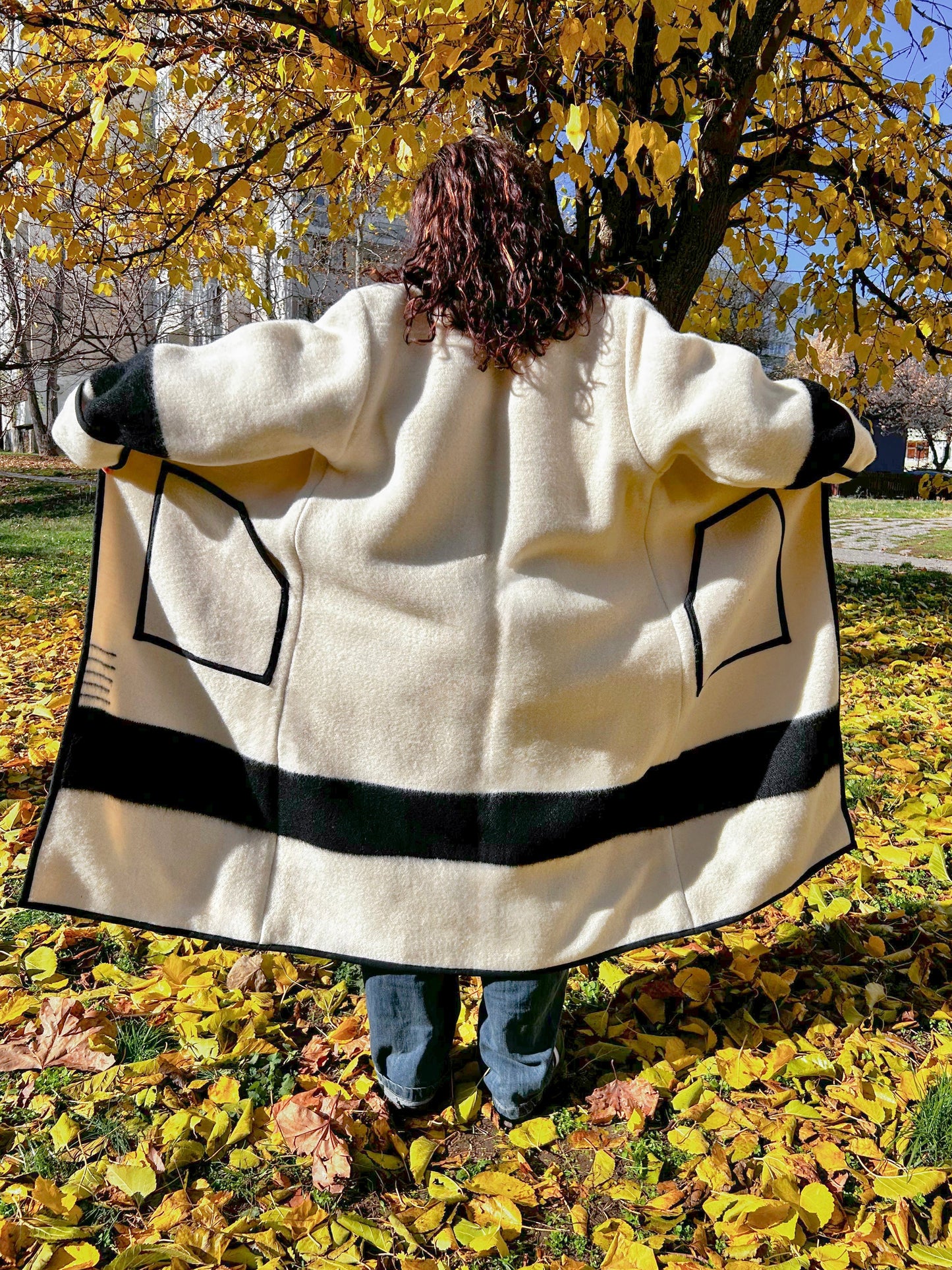 A woman wearing a loose blanket kimono coat or statement coat.