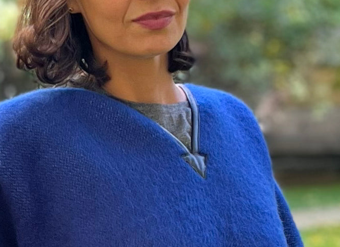 Person wearing a traditional blanket cape or mexican poncho with black elements