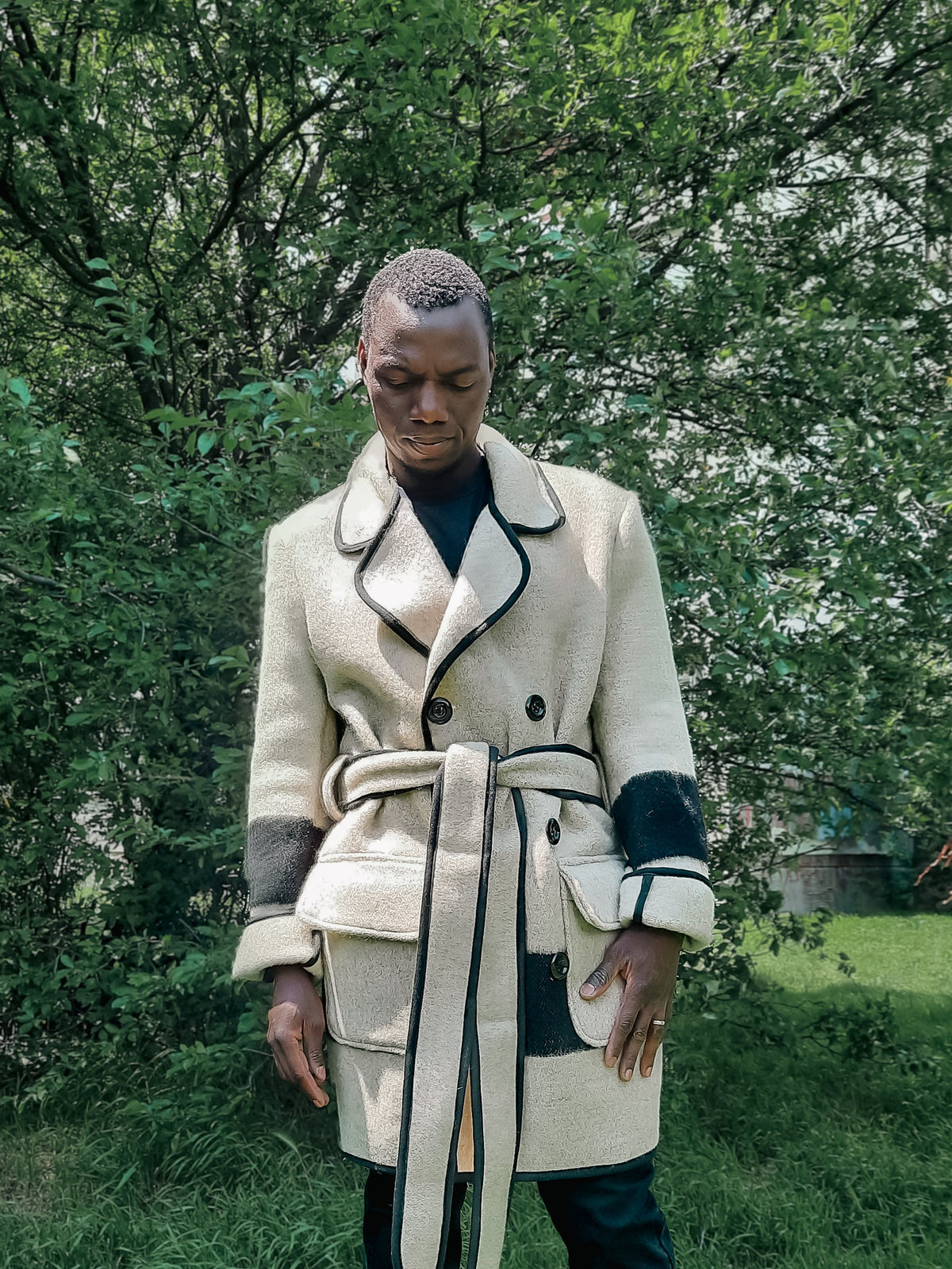 Man wearing a gray wool peacoat and blanket jacket with vintage inspired collar and double breasted closure.
