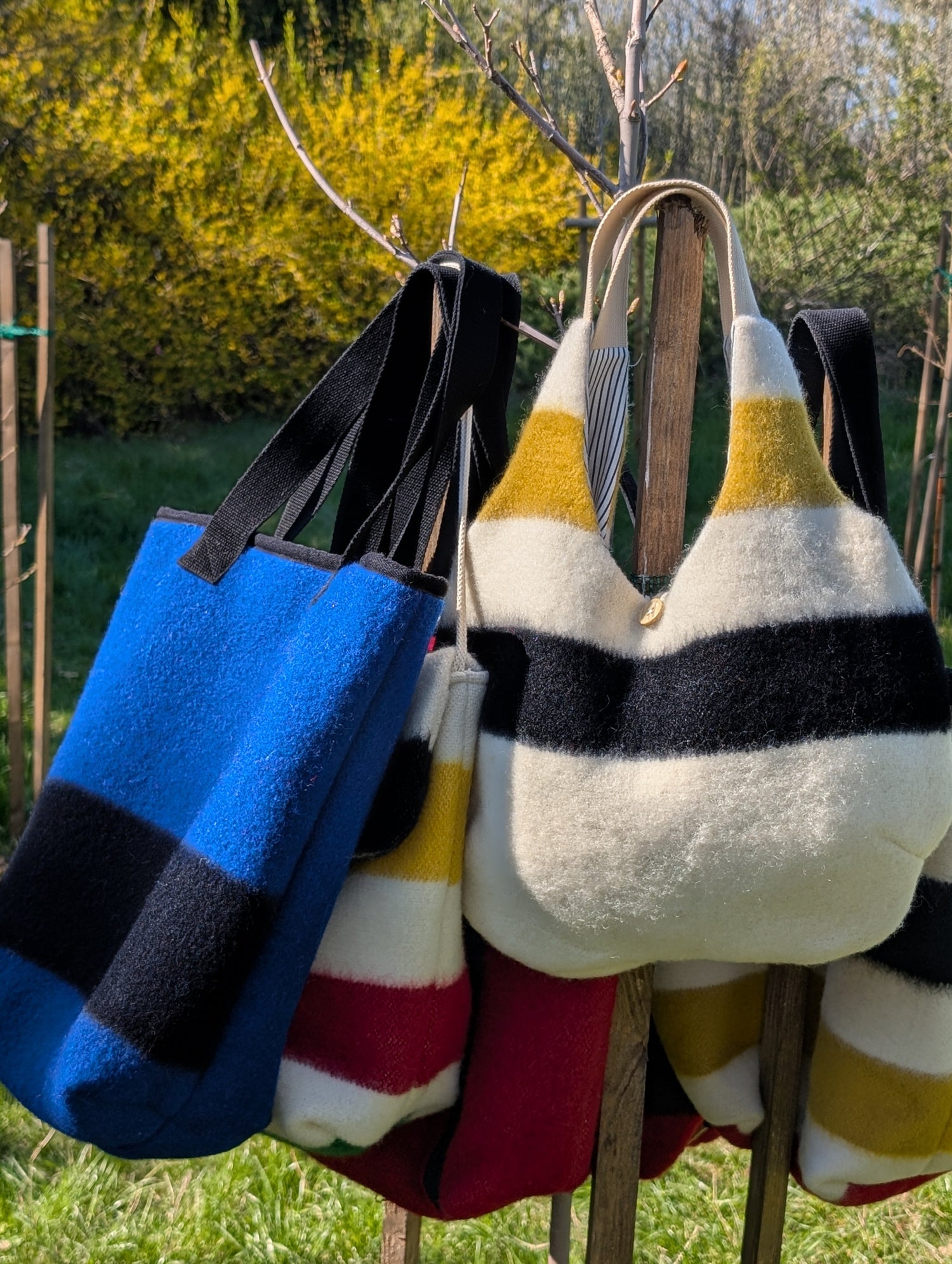 Various models of wool blanket bags in different colors and stripes. Upcycled from handwoven heritage blankets. 