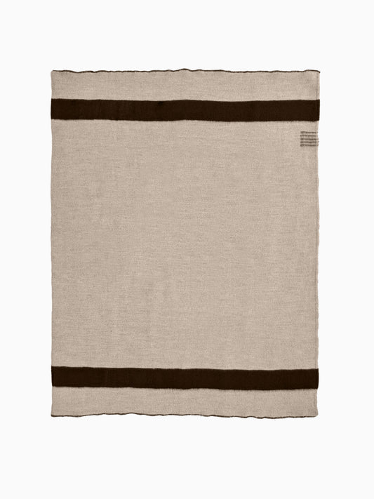 Top-down flat-lay of a natural warm gray wool blanket featuring horizontal black stripes.