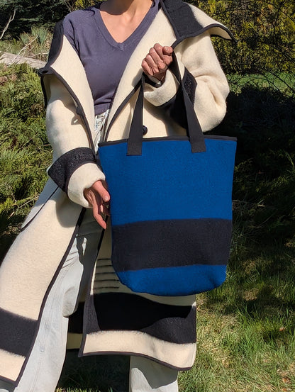 Woman posing with a blue wool shopping bag or blanket tote bag upcycled from a locally handwoven eco natural wool blanket. 