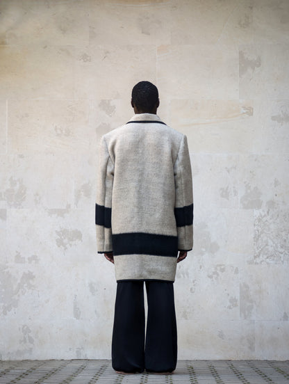Back view of a light gray handwoven wool blanket coat with peacoat design.
