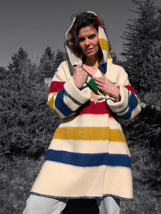 A woman wearing a loose comfortable traditional  midi capote coat with candy stripe design.