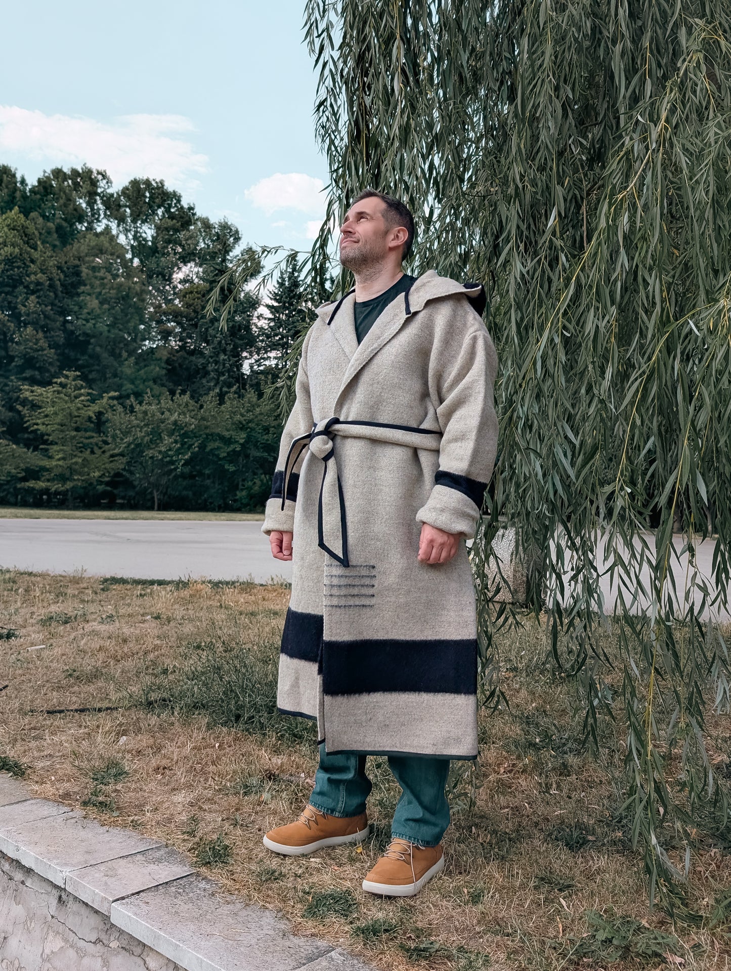 A man posing with a thick warm coat, mountain man coat associated with native american history and suitable for rendesvous and reenactment.