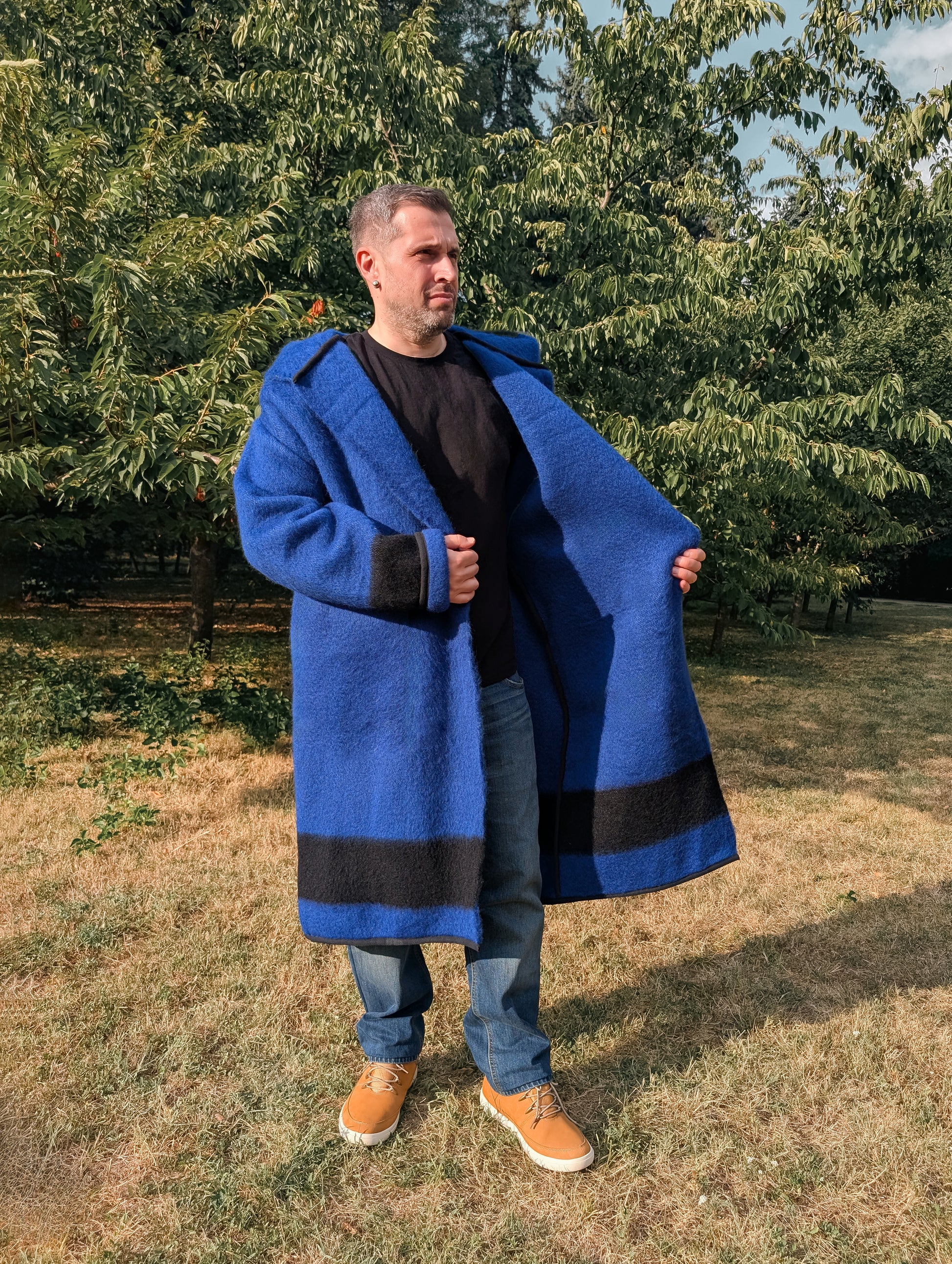 Man wearing blue revolutionary coat, made from traditionally handwoven woolen stripe blanket