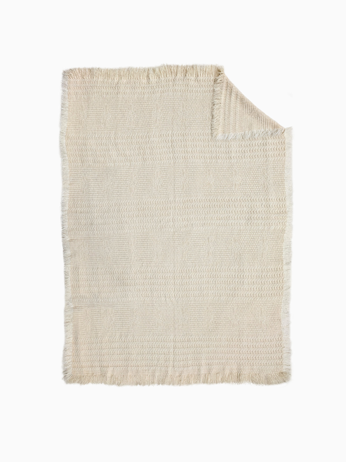 An organic wool blanket in natural ight beige or cream color, featuring a textured basketweave pattern and fringed edges.