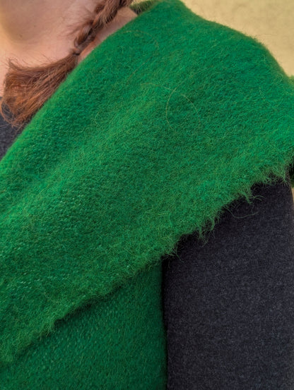 Close-up texture detail of handwoven emerald green virgin wool sleeveless waistcoat.