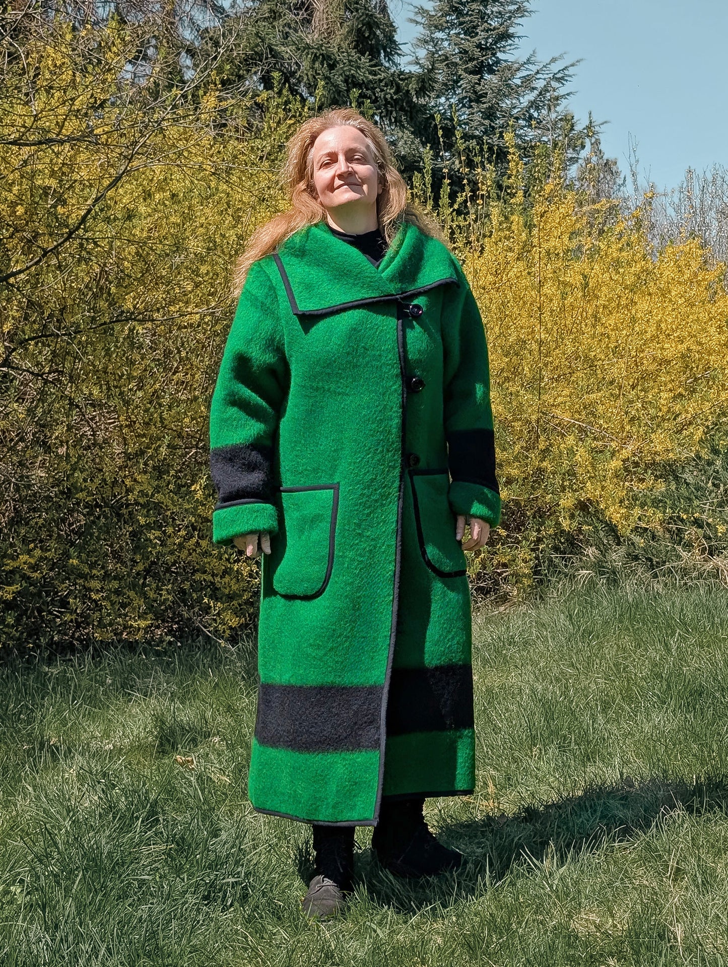 Long slow fashion green coat with a wide collar and single-breasted closure, upcycled from traditionally handwoven wool blanket.