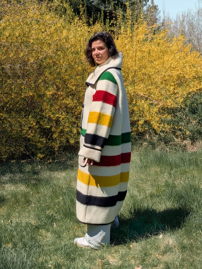 Woman showing the side view of a tailor made long wool collar coat or duster coat, made of recycled ethnic wool blanket.