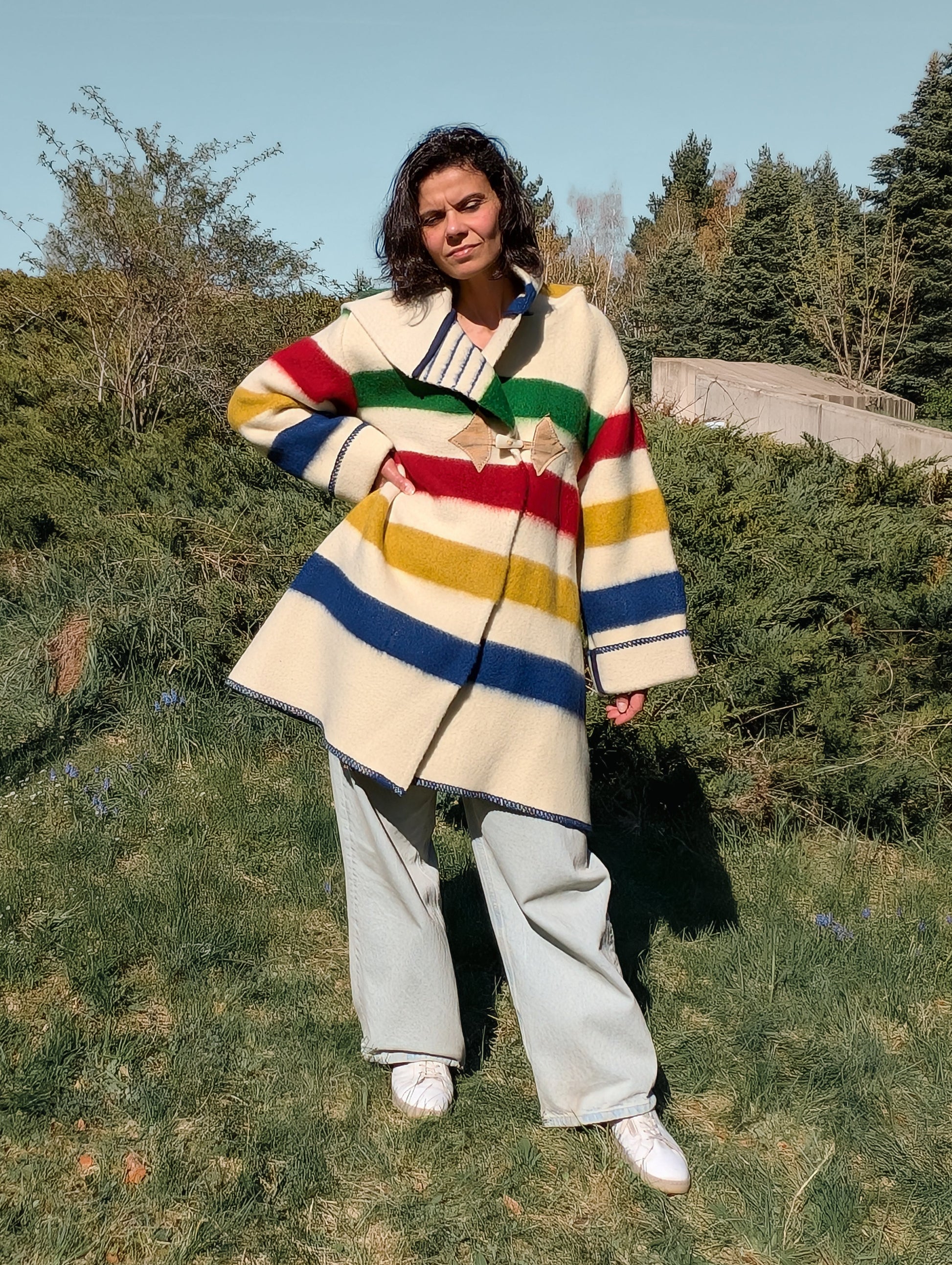 Woman posing with a midi swing coat with a large deep hood, upcycled from single pure wool blanket.