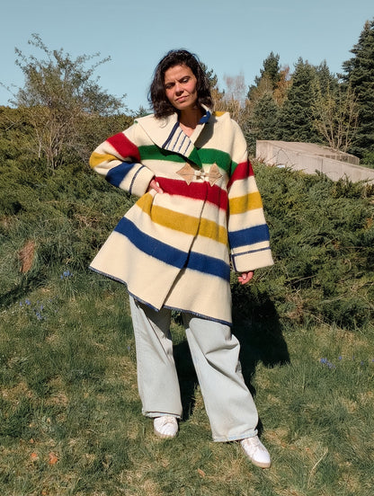 Woman posing with a midi swing coat with a large deep hood, upcycled from single pure wool blanket.