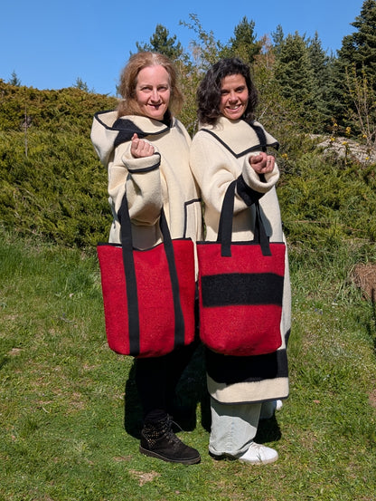 Two people holding red tote bags matching their offwhite woolen jackets. All garments and accessories are upcycled from pure wool stripe blankets.