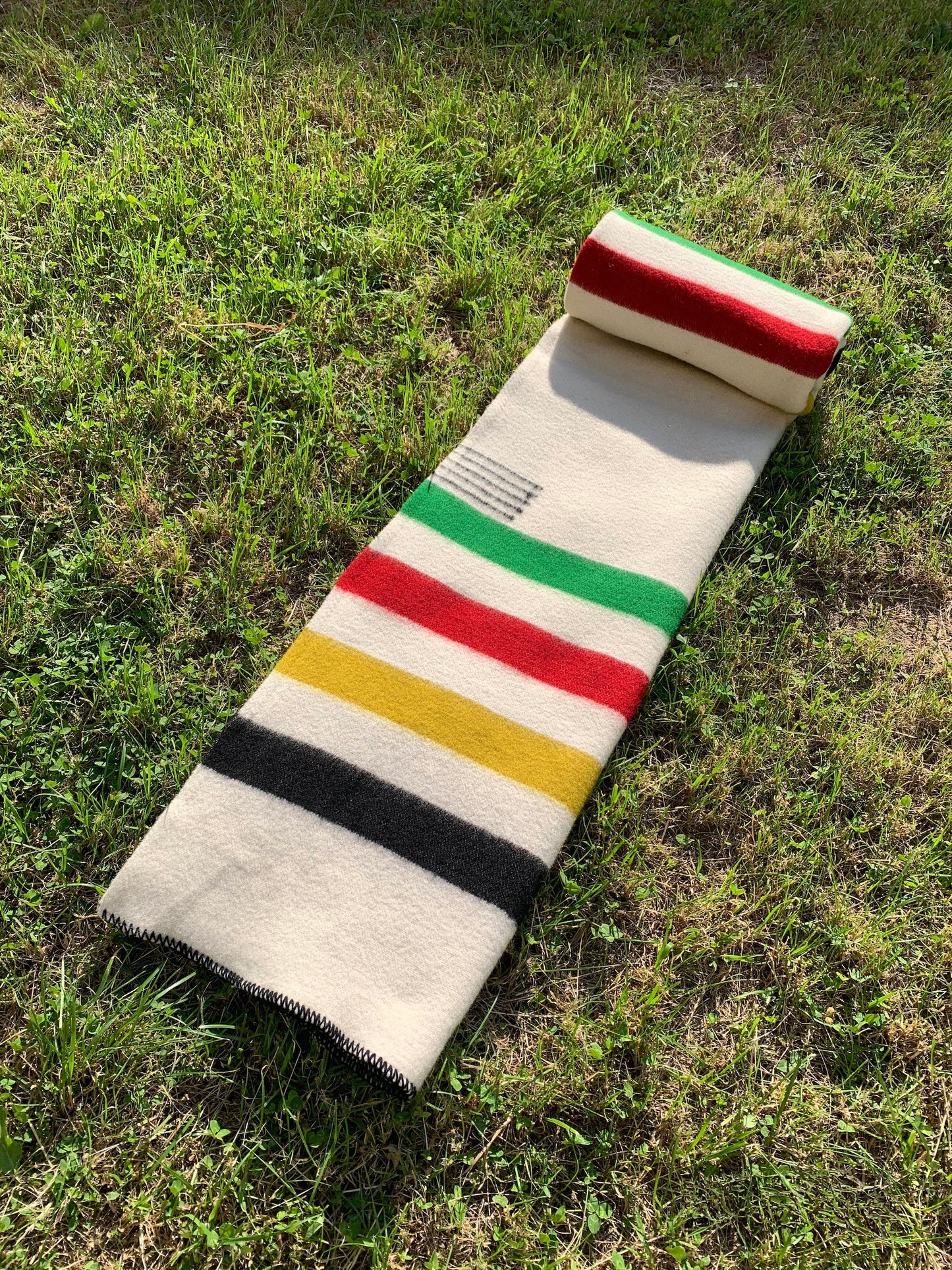 blanket in ivory with 4 multicolor stripes, handwoven from sustainable natural sheep wool.