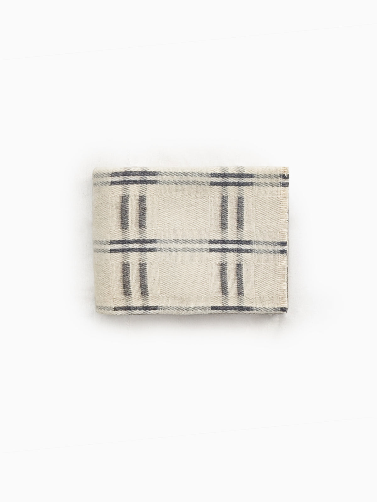 Folded handwoven undyed wool blanket in natural ivory and taupe showing check pattern and wool texture