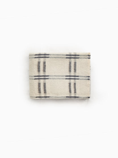 Folded handwoven undyed wool blanket in natural ivory and taupe showing check pattern and wool texture