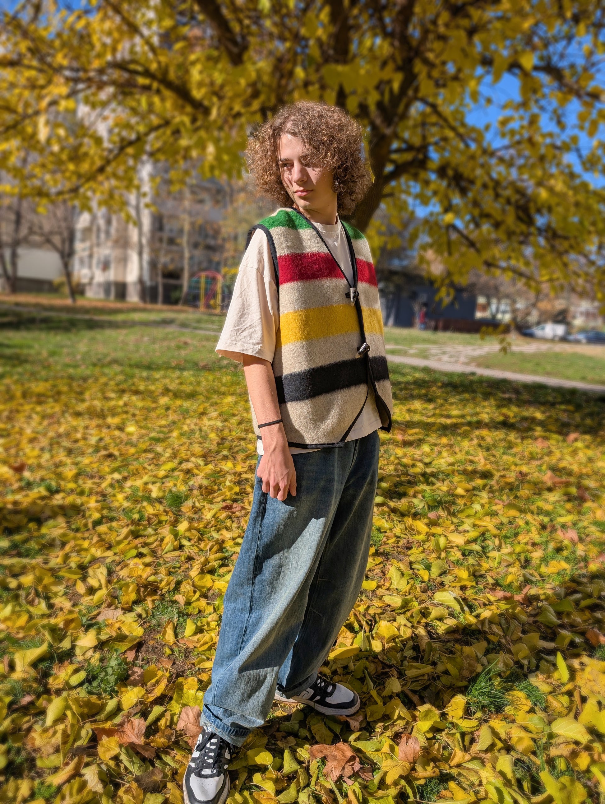 Man wearing a stylish upcycled blanket vest or sleeveless jacket, made of multistripe wool blanket. Unisex and great on all ages, suitable for everyday wear, events, and walks in the nature.