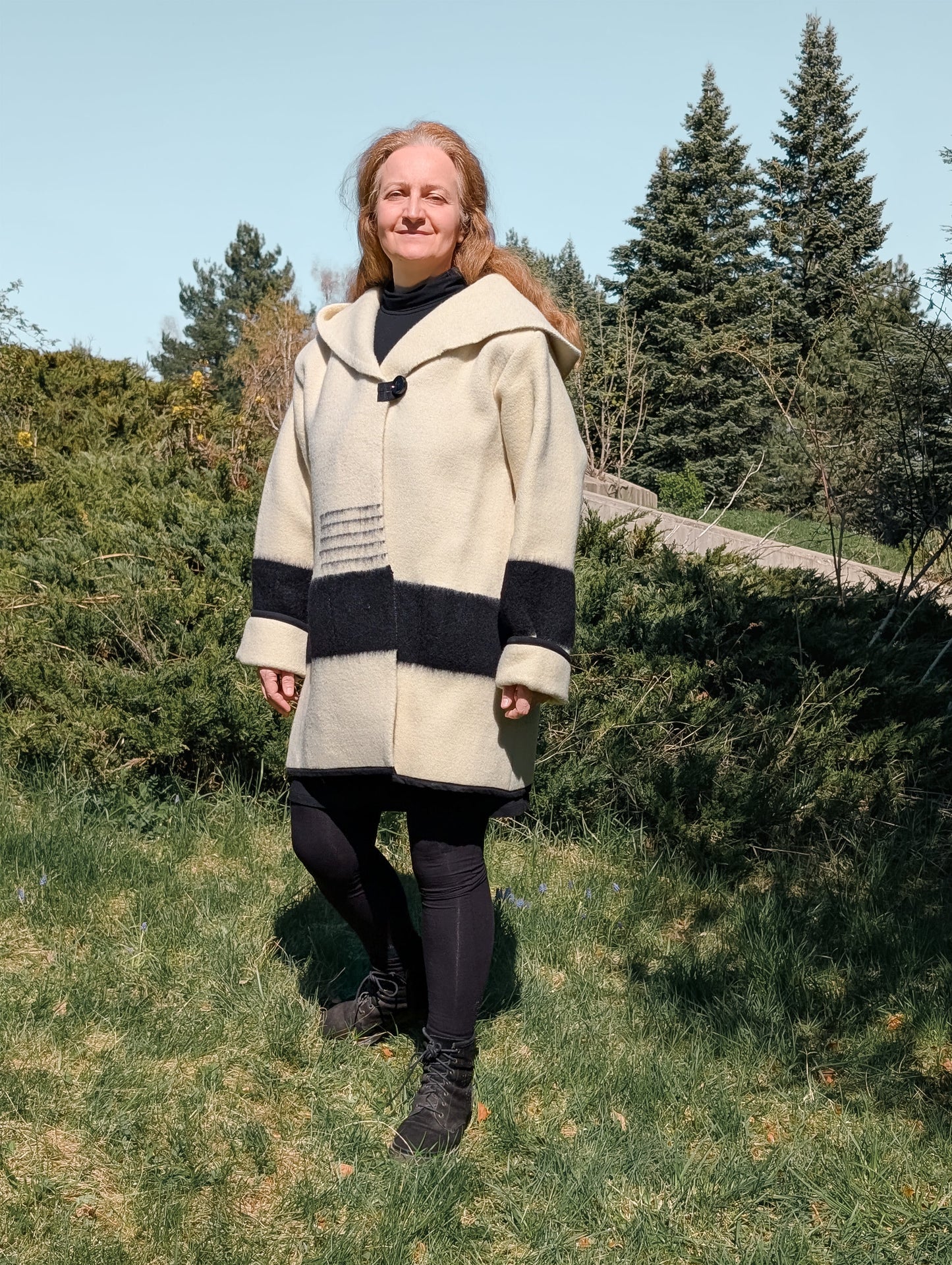 A woman wearing a wool blanket coat for women, handcrafted from original organic wool blanket