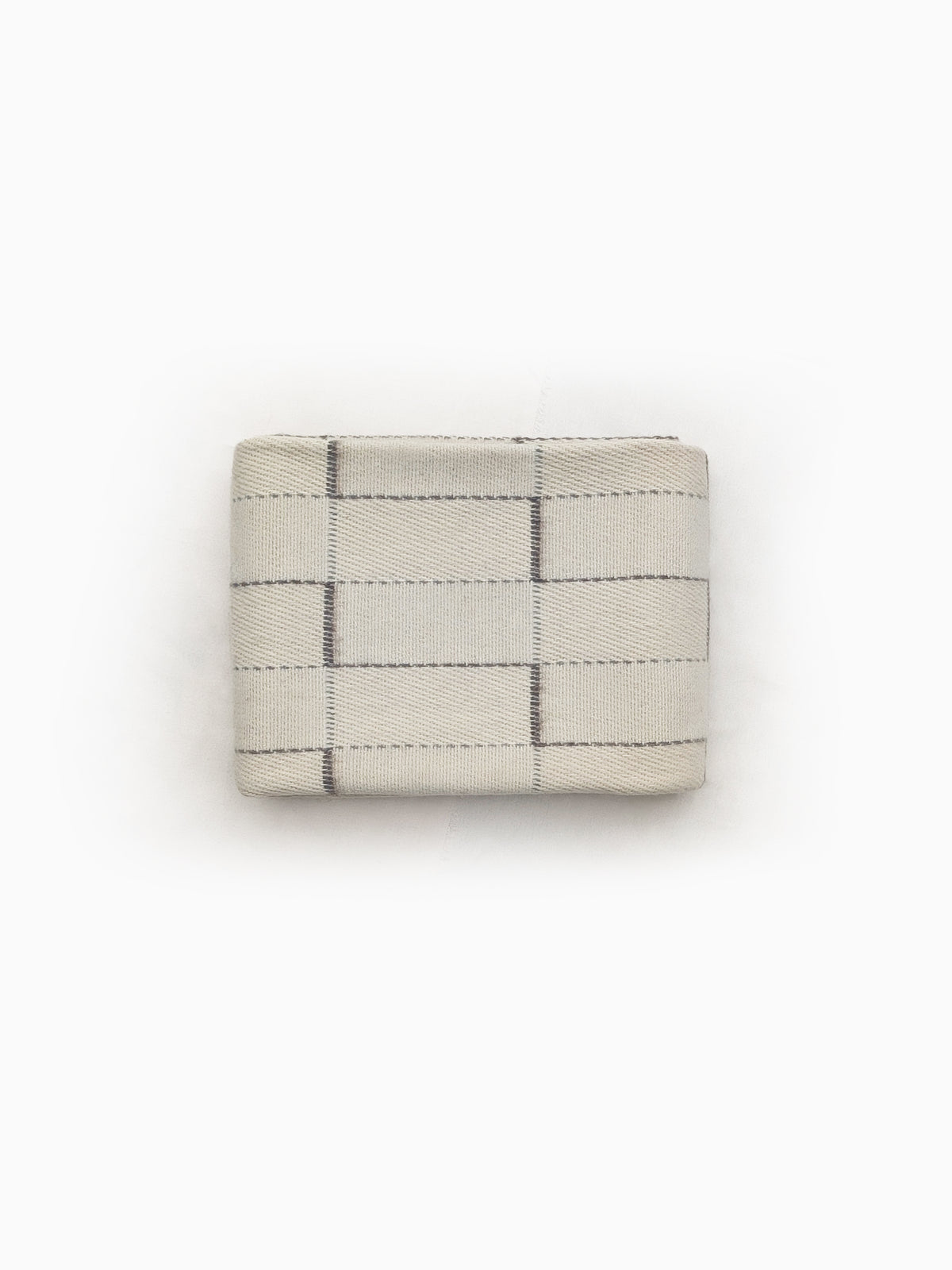 Folded undyed handwoven wool blanket in natural ivory/cream or offwhite with geometric grid weave detail.