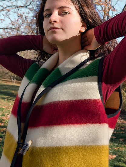 Person wearing a colorful striped blanket vest made from repurposed native original wool blanket.