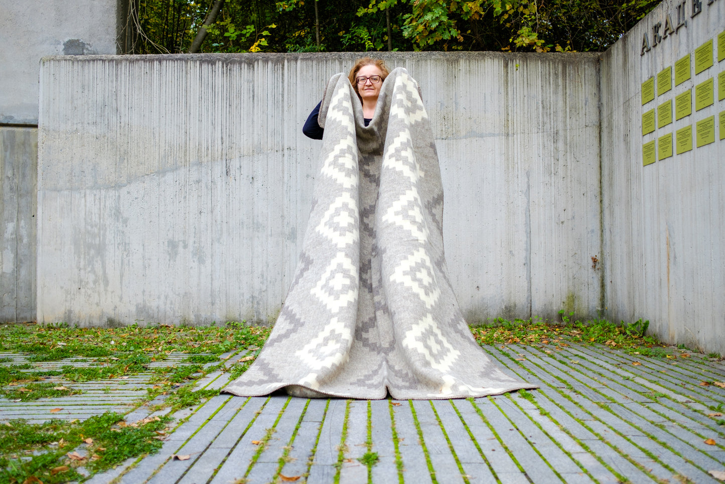 Person holding a large thick woolen blanket with ancient aztec diamond pattern. Warm, cozy and beautiful, ideal for modern minimalistic interior. 