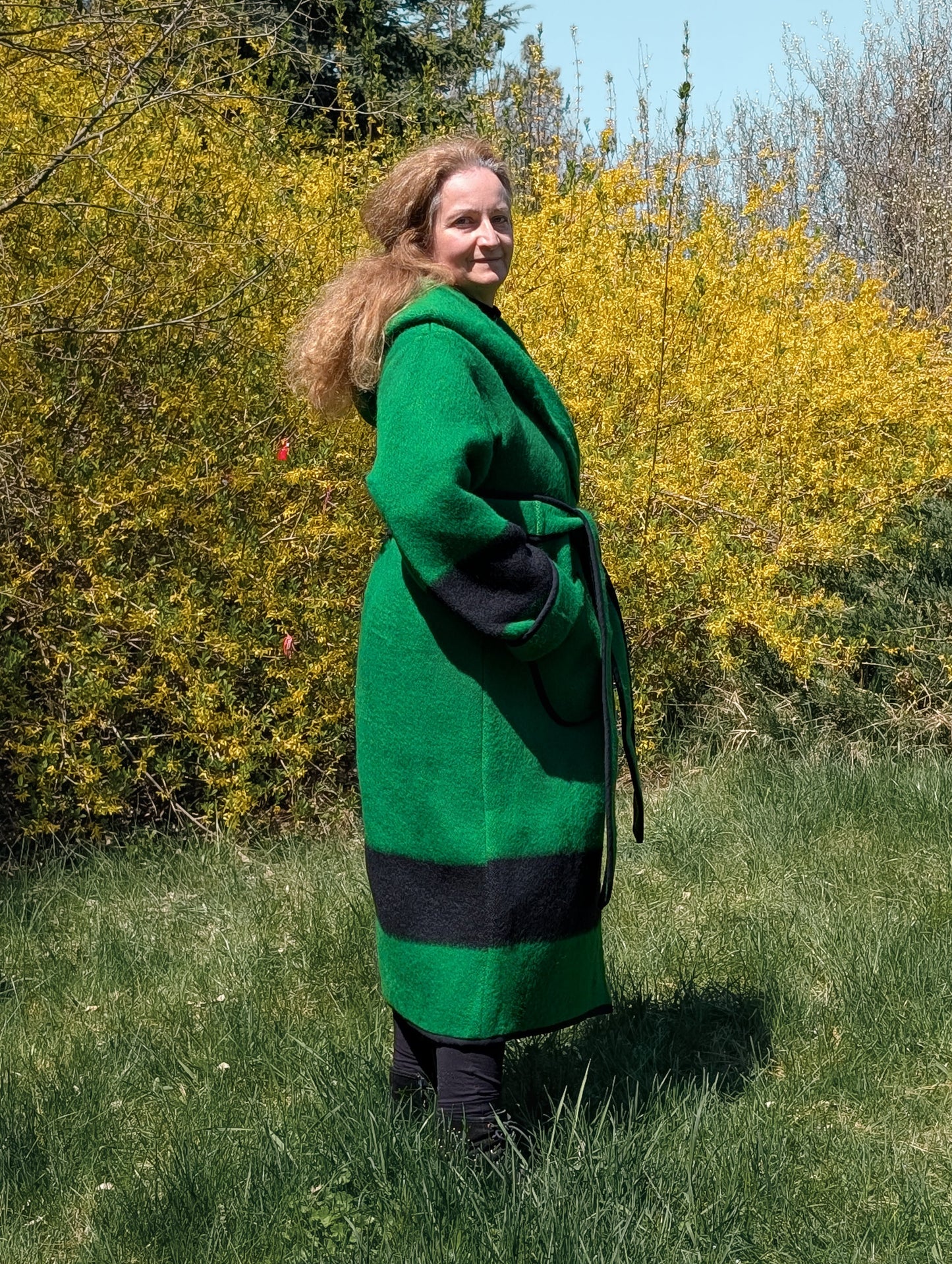 Side view of long wrap coat with a wide hood and belt made from upcycled virgin wool blanket. 