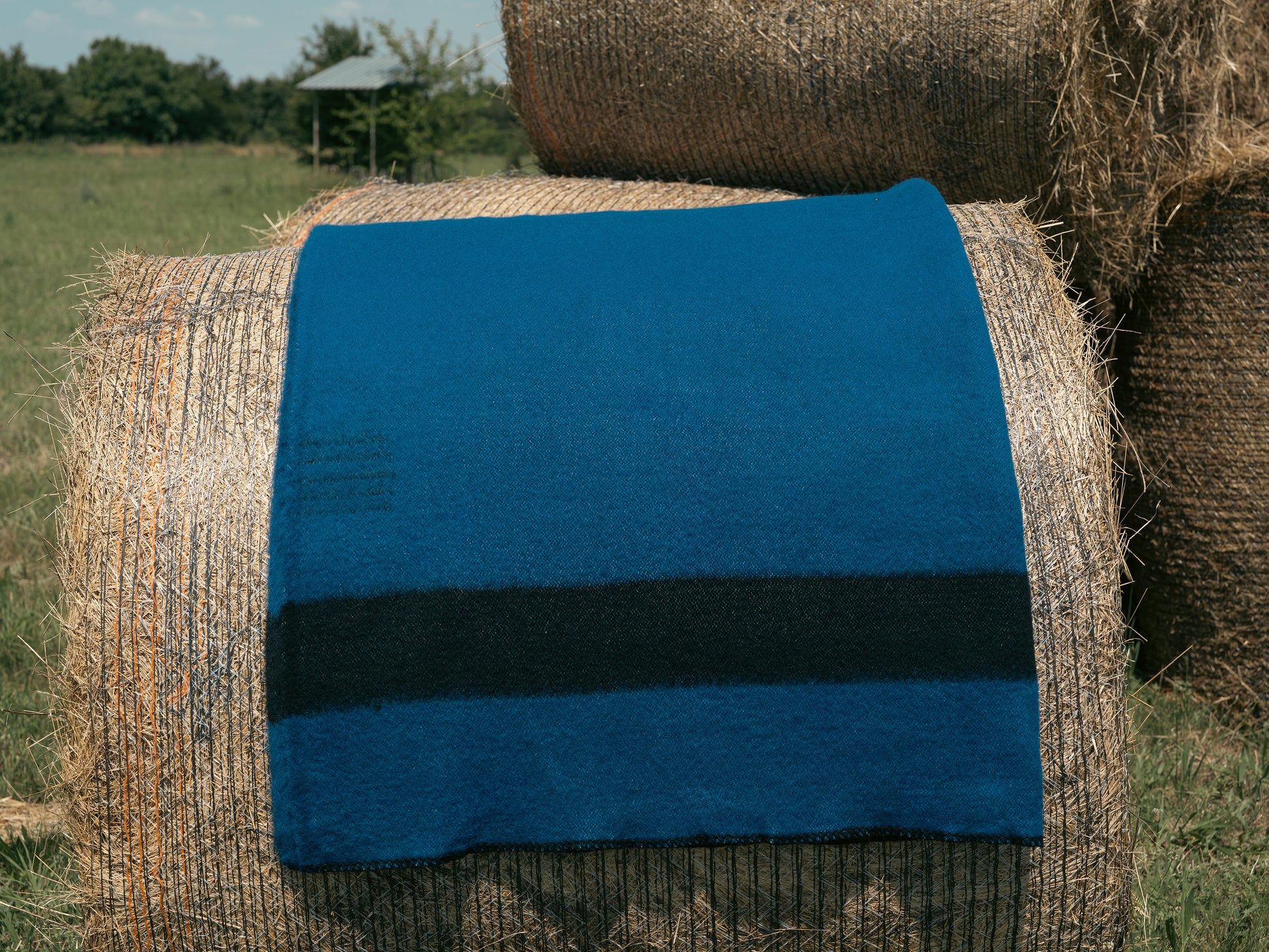 Canada wool blanket in deep blue, with a black stripe at each end, traditional heirloom handcraft, made locally. Ideal for reenactment, travel, hygge home and rustic cabin decor.