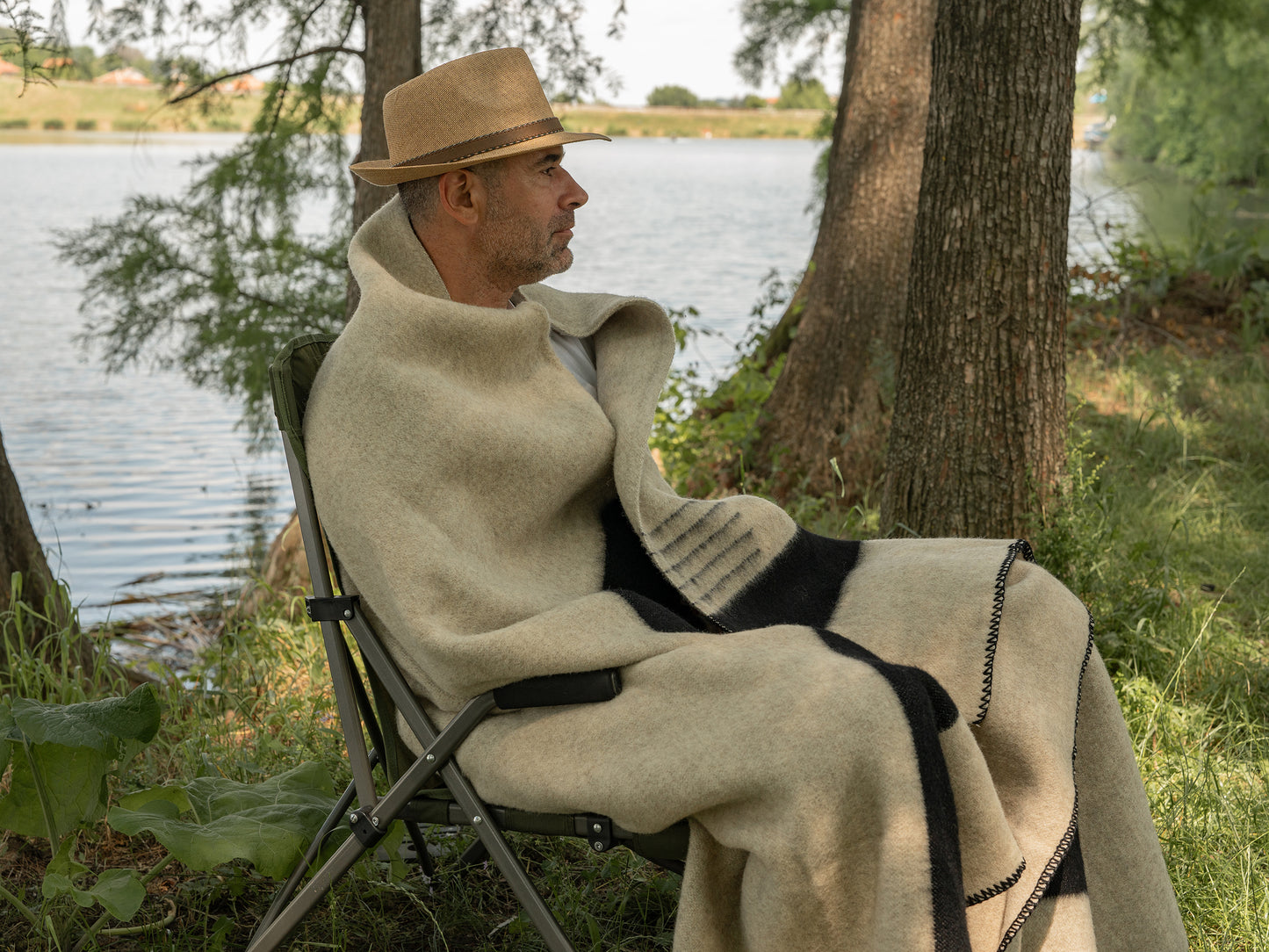 A man wrapped in a gray natural wool blanket with minimalist design, great for scandinavian and cabin rustic decor. 
