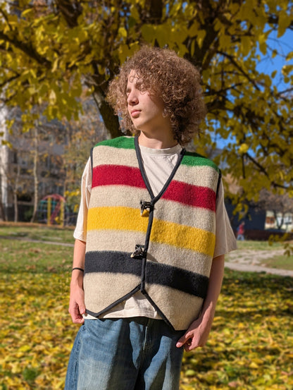 Young person wearing a colorful striped vest outdoors, upcycled from a natural wool blanket. 