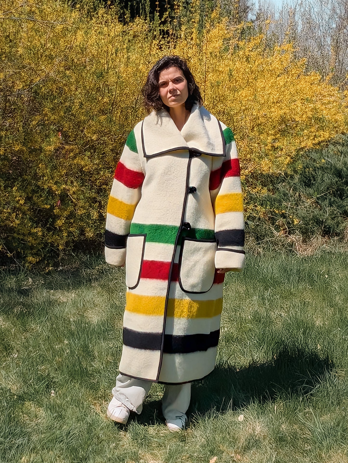 Woman wearing a candy stripe native american recycled wool blanket collar coat, featuring a wide lapel and button closure.