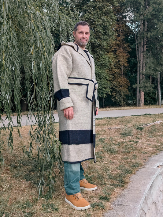 A man wearing a natural gray wool blanket capote coat with a belt.