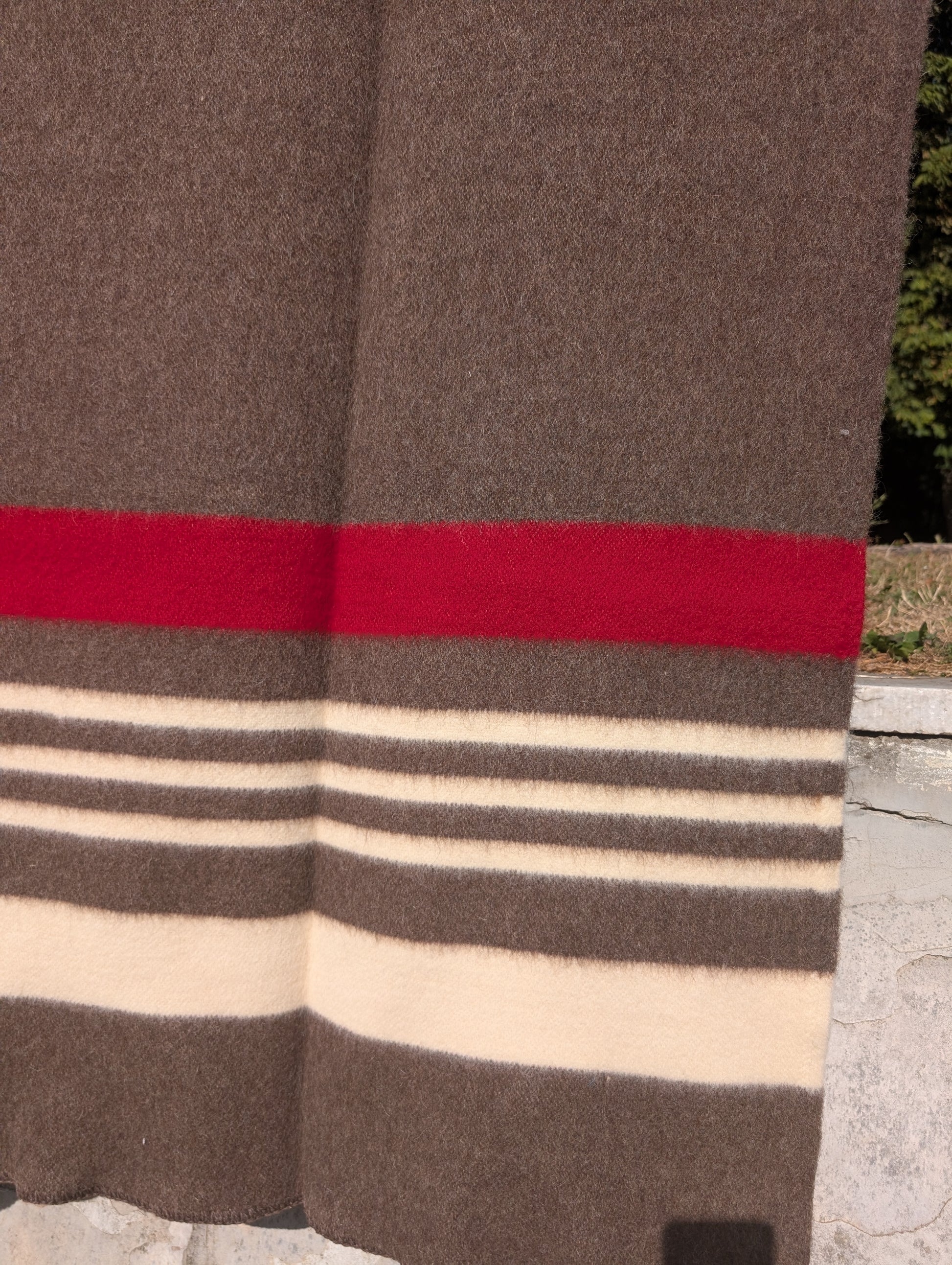 Close-up of a vintage wool blanket with red and beige stripes, made from artisan heirloom wool