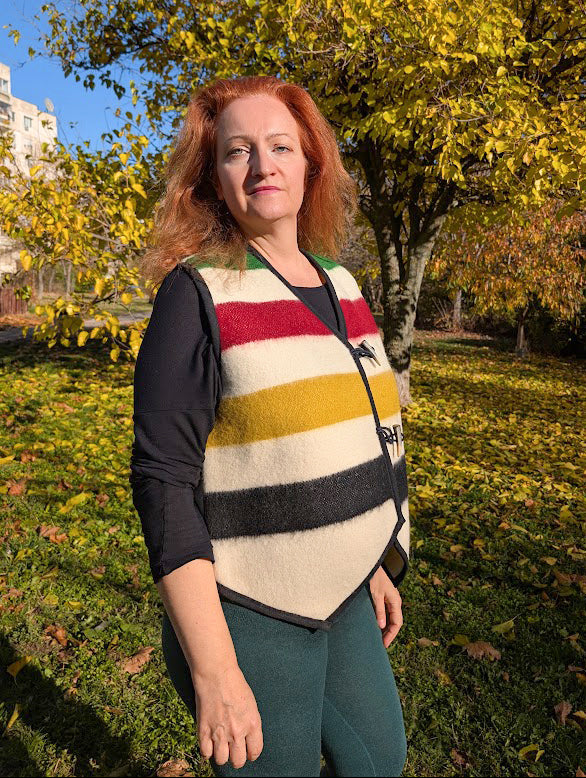 Woman wearing a handmade stripe gilet, upcycled from a local traditionally made blanket.