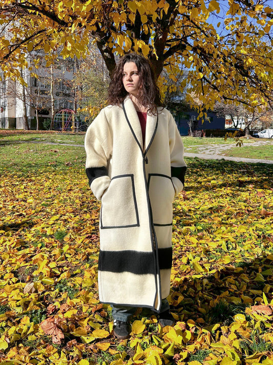 A young woman wearing an eco friendly coat or blanket cardigan coat with front pockets.