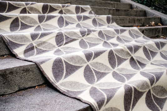 Patterned wool blanket in undyed earth tones with geometric circle design on a set of concrete steps