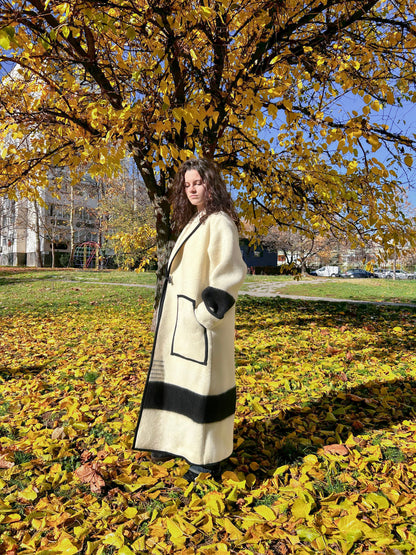 Woman in a Bohemian coatwith ivory base and wide black stripes upcycled from a white blanket.