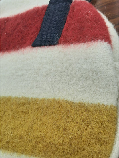 Close-up of a circle shopping bag made of  natural wool surface with red, white, and mustard yellow stripes.