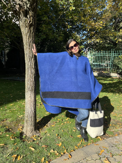 Woman wearing a unisex blanket poncho in iconic heritage style.