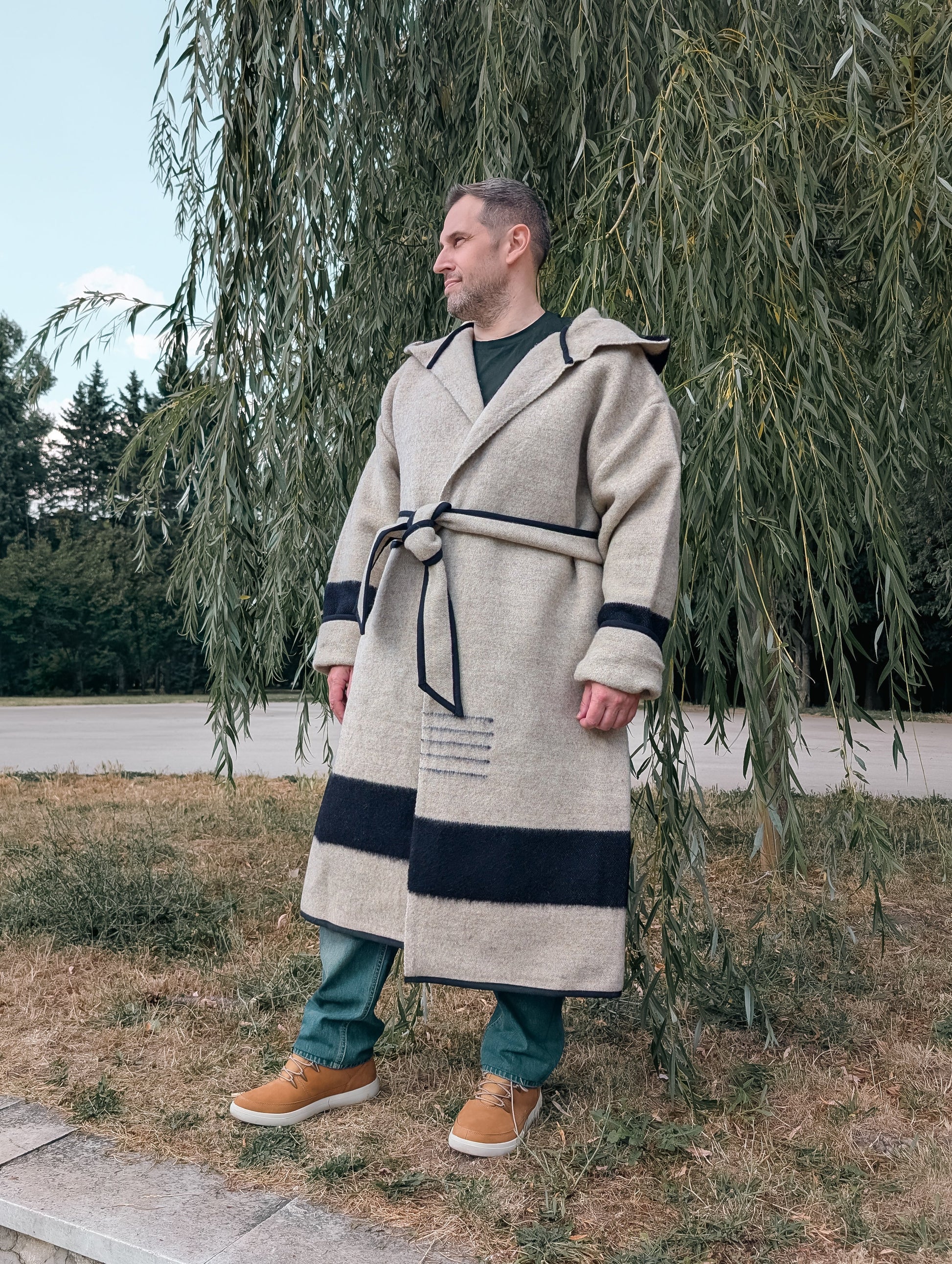 Man wearing a natural gray wool wrap coat, upcycled from a handwoven virgin wool blanket.