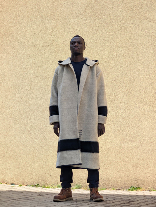 Man wearing a natural gray wool wrap coat, upcycled from a handwoven virgin wool blanket.