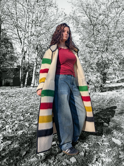 A girl wearing oversized duster coat with stand collar, two front pockets and single breasted. The background is a park setting