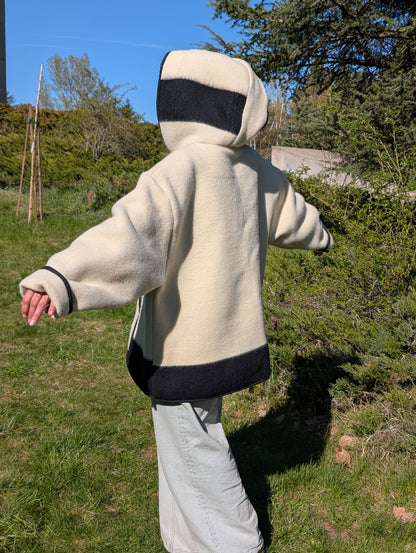 Woman with a handmade boho anorak or street hoodie style made of thick warm heavy pure wool stripe blanket in cream base.