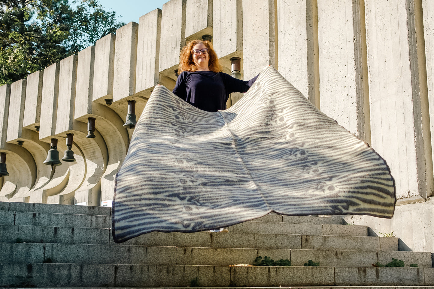 Person hoding a handwoven tribal wool blanket with ethnic safari zebra stripes in undyed earth tones 