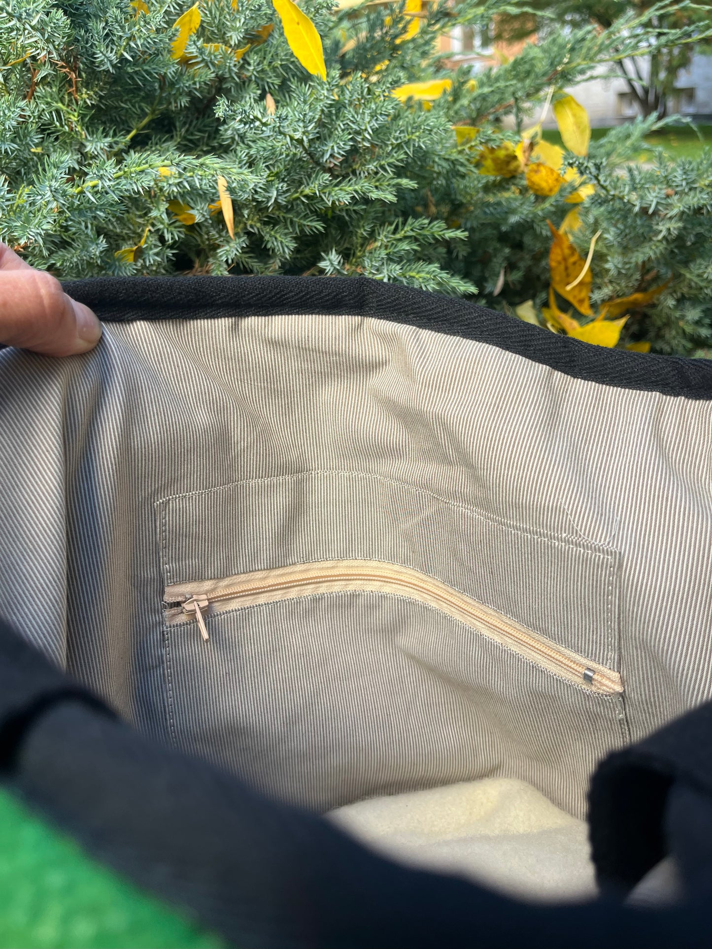 Close-up of ahandmade tote bag interior with a zipper pocket inside and a pure cotton lining of tiny stripes.