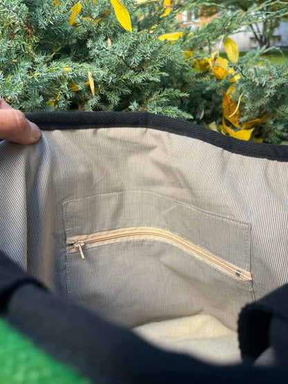 Close-up of ahandmade tote bag interior with a zipper pocket inside and a pure cotton lining of tiny stripes.