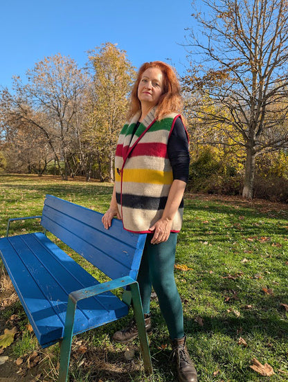 Woman wearing a multistriped sleeveless sweater made from original handwoven wool blanket.