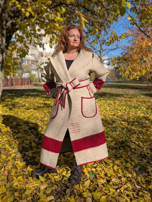 Heritage style long gray blanket capote coat with red stripe, wrapped with a belt  and a hoodie going down into a shawl collar. 
