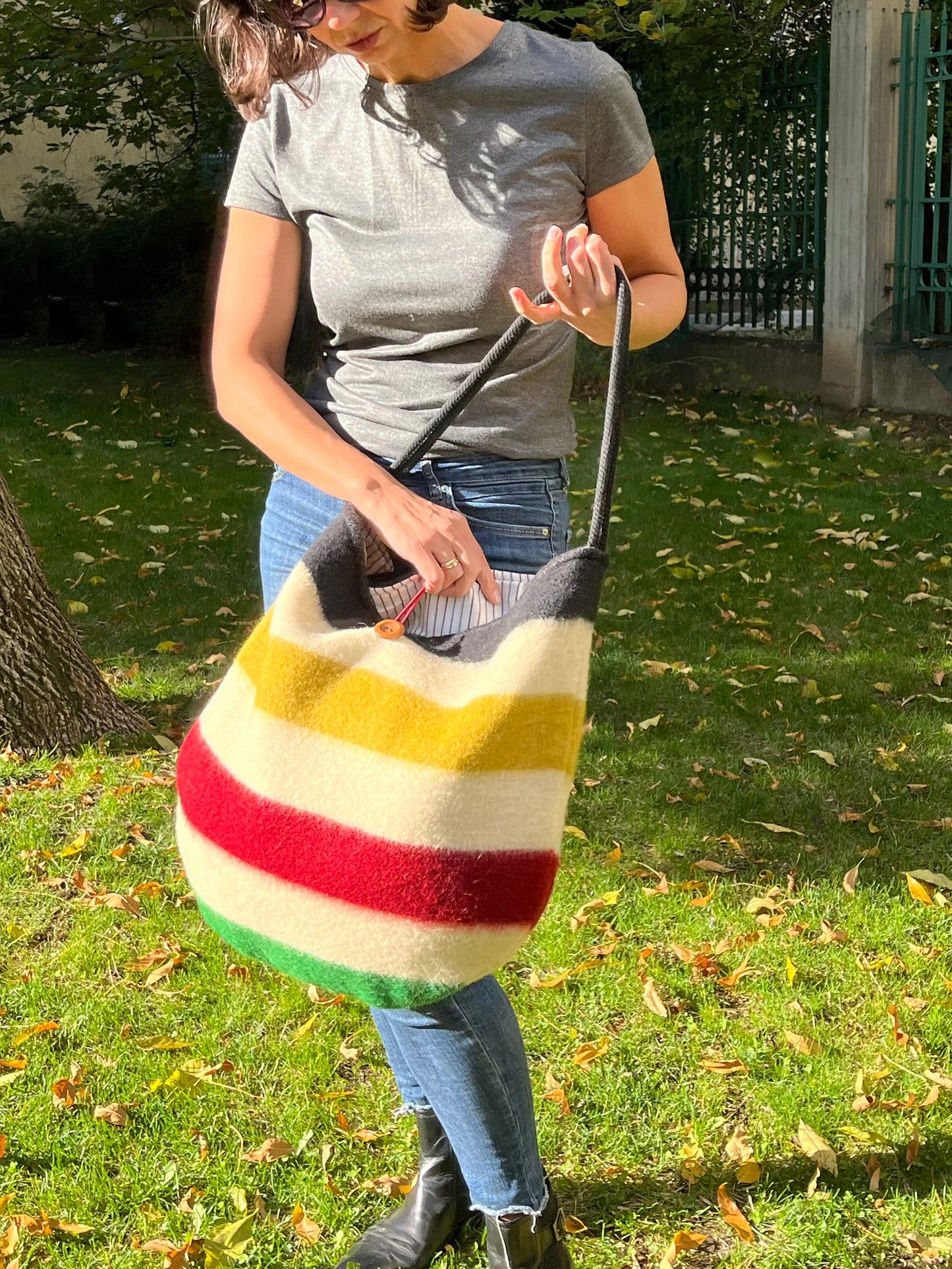 Woman holding a colorful striped bag, made of traditional blankets with indigenous stripes pattern.