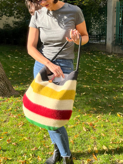 Woman holding a colorful striped bag, made of traditional blankets with indigenous stripes pattern.